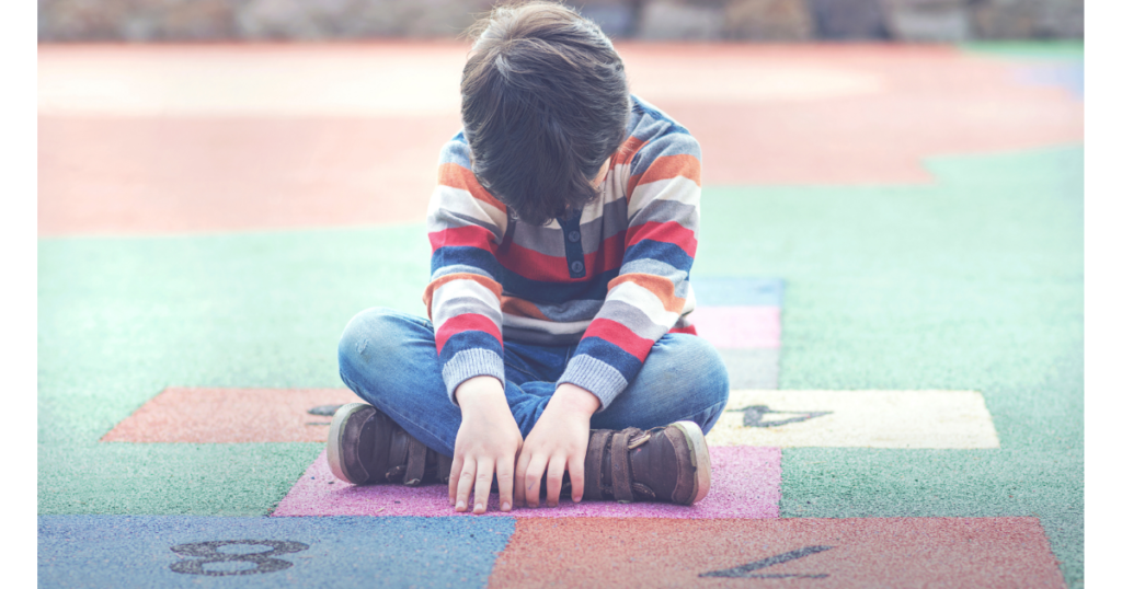 Child sitting alone showing signs of rejection sensitivity
