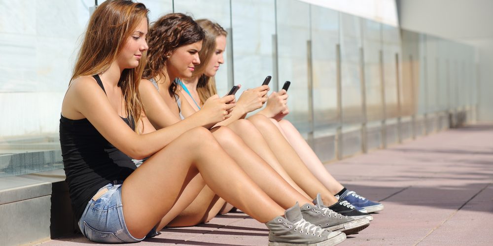 Group,Of,Three,Teenager,Girls,Sitting,On,The,Floor,Typing